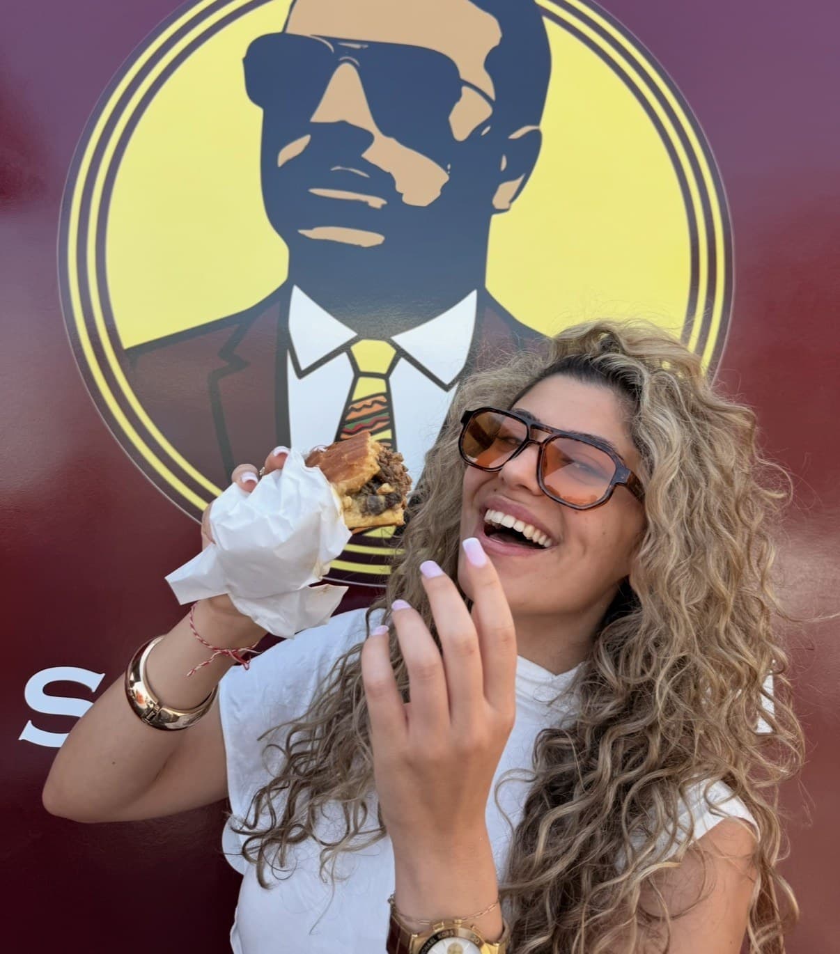 Lachender Gast mit Sandwich vor dem Pappou’s Logo am Truck